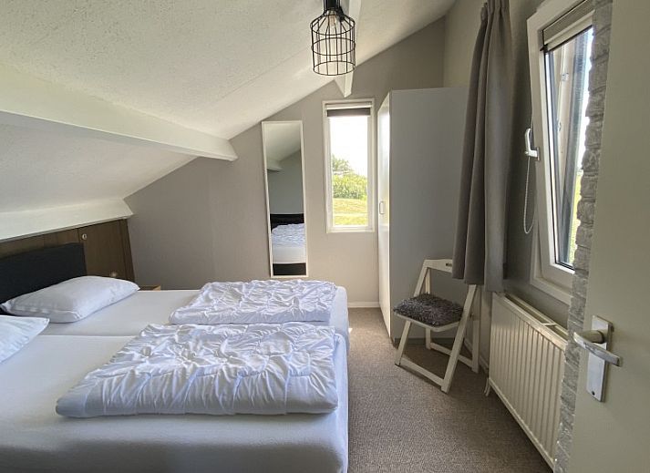 Buitenterras van Luxe 8 persoons Golf Villa Texel in De Cocksdorp met grote eettafel, ideaal voor gezellige diners in de natuur.