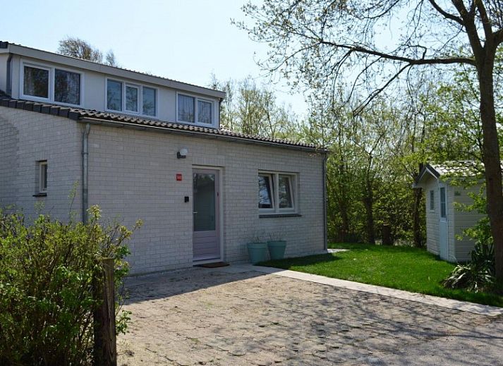 Bungalow 543 in De Cocksdorp, Texel biedt een charmante buitenkant omringd door groen, ideaal voor een ontspannen vakantie op de Waddeneilanden.