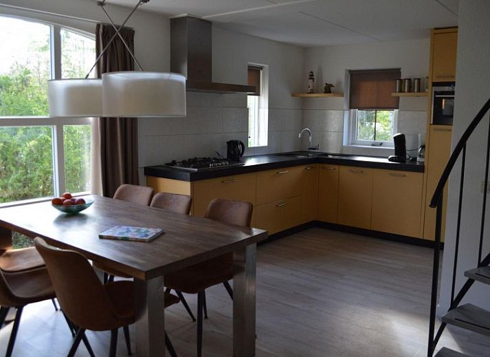 Gezellige eetkamer in Bungalow 543, De Cocksdorp, Texel. Geniet van een moderne binnenruimte met natuurlijk licht en een stijlvolle keuken.