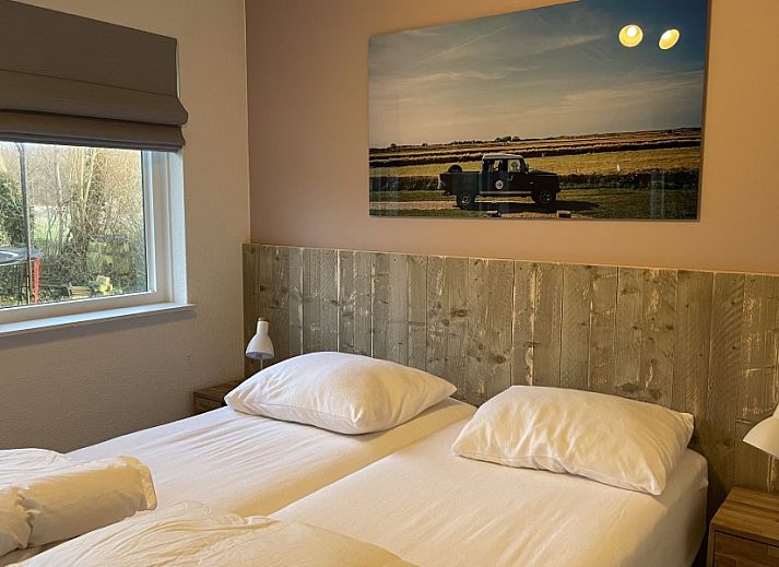 Terrasse des Ferienhauses Kaap Zilt Texel in De Cocksdorp, Texel, mit Sitzecke und gruener Umgebung.