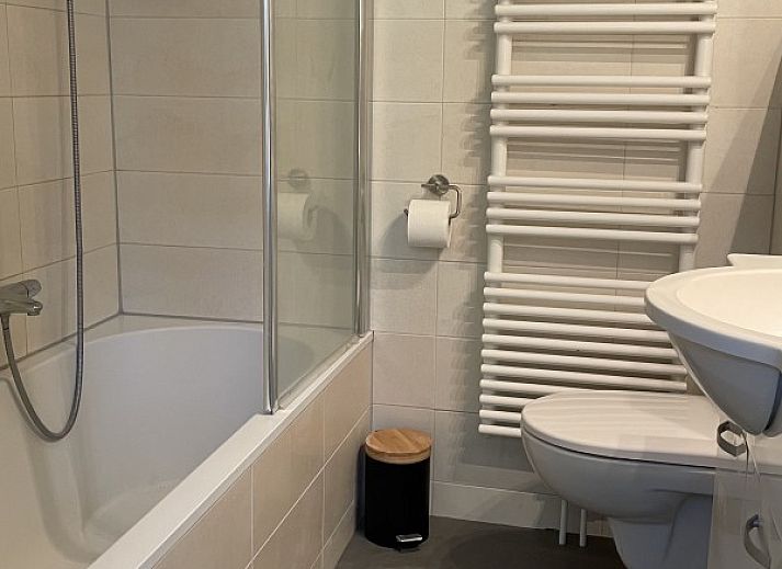 Terrasse des Ferienhauses Kaap Zilt Texel in De Cocksdorp, Texel, mit Sitzecke und gruener Umgebung.