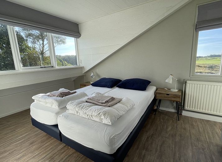 Terrasse des Ferienhauses Kaap Zilt Texel in De Cocksdorp, Texel, mit Sitzecke und gruener Umgebung.