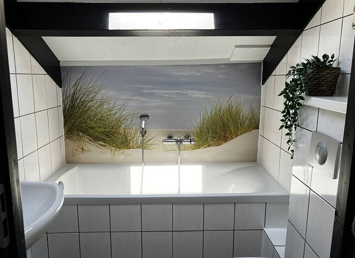 Cozy living room of Texel Beachhouse 23 in De Cocksdorp with a cozy fireplace and views of nature.