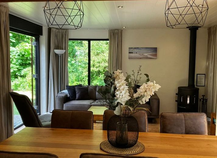 Cozy living room of Texel Beachhouse 23 in De Cocksdorp with a cozy fireplace and views of nature.