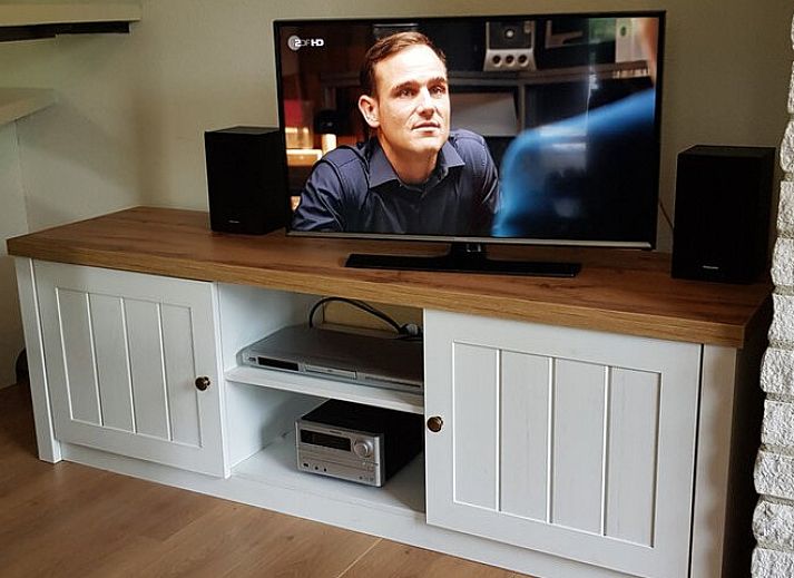 Terrace of Ferienperle vacation home in De Cocksdorp, Texel, surrounded by greenery.