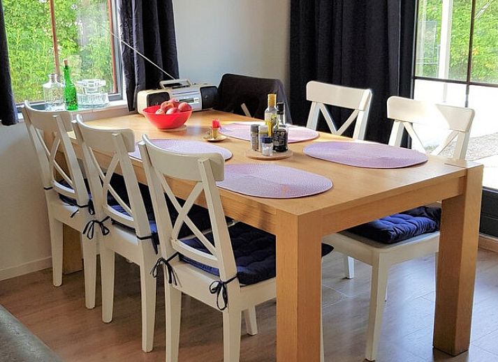 Terrace of Ferienperle vacation home in De Cocksdorp, Texel, surrounded by greenery.