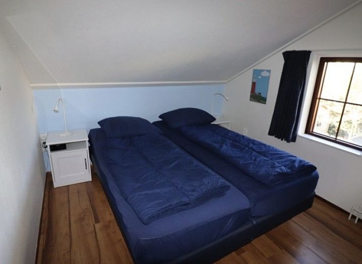 Terrace of Ferienperle vacation home in De Cocksdorp, Texel, surrounded by greenery.