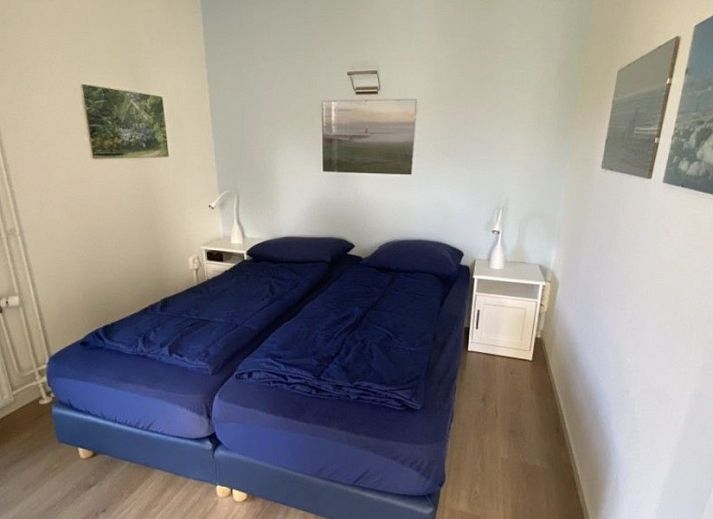 Terrace of Ferienperle vacation home in De Cocksdorp, Texel, surrounded by greenery.