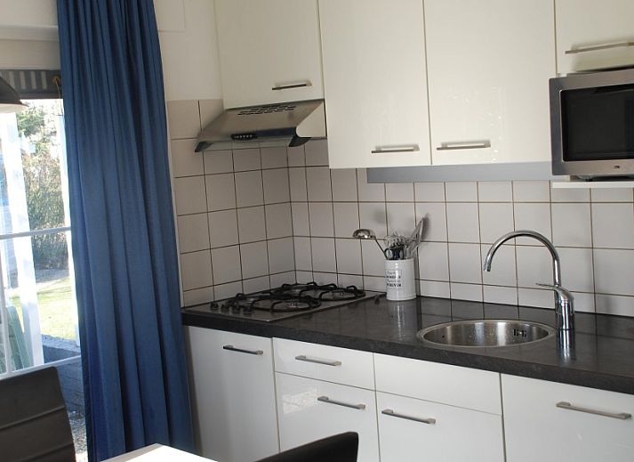 Bungalow Krim 661 with Sauna, Stuha, and BBQ in De Cocksdorp, Texel, with a sunny veranda surrounded by green nature.