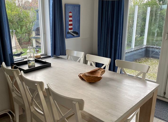 Cozy living room of Krim 661 with sauna, Stuha, and BBQ, a bungalow in De Cocksdorp, Texel, with comfortable seating area and fireplace.