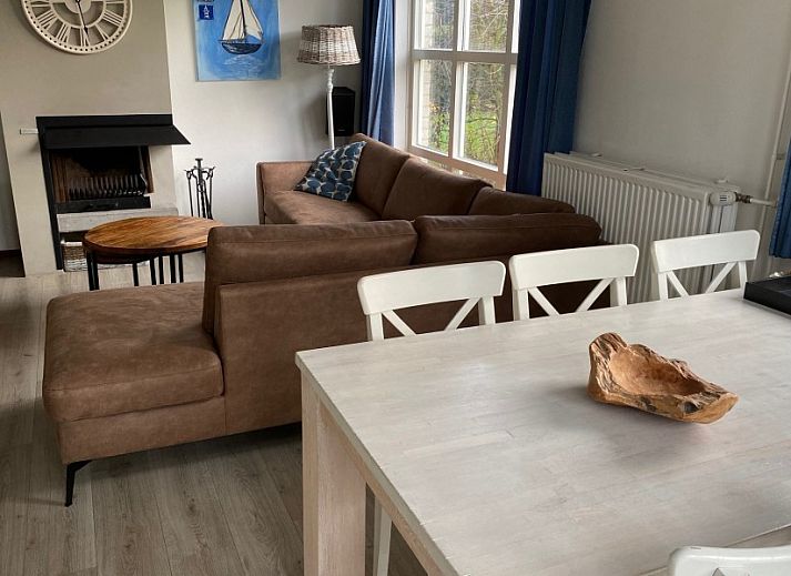 Cozy living room of Krim 661 with sauna, Stuha, and BBQ, a bungalow in De Cocksdorp, Texel, with comfortable seating area and fireplace.