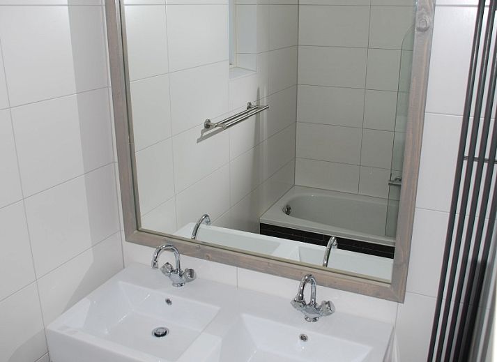 Cozy living room of Krim 661 with sauna, Stuha, and BBQ, a bungalow in De Cocksdorp, Texel, with comfortable seating area and fireplace.