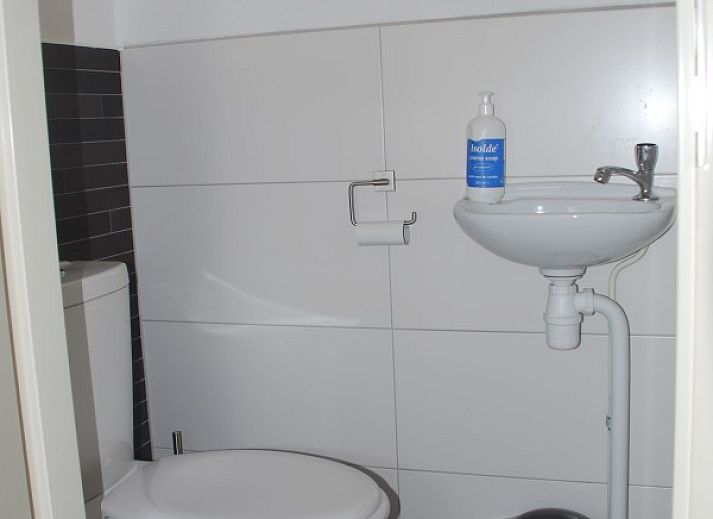 Cozy living room of Krim 661 with sauna, Stuha, and BBQ, a bungalow in De Cocksdorp, Texel, with comfortable seating area and fireplace.