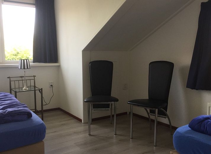 Cozy living room of Krim 661 with sauna, Stuha, and BBQ in De Cocksdorp, Texel. Comfortable bungalow with spacious sitting area and view of nature.