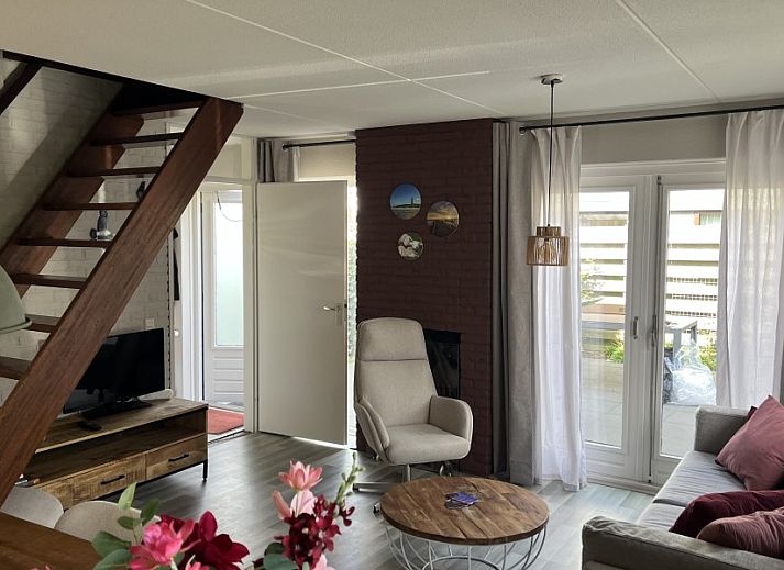Gezellige woonkamer van TXL Huisje 299 in De Cocksdorp, Texel met comfortabele zithoek en toegang tot het terras.