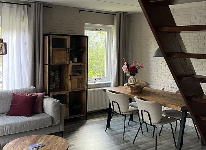 Gezellige woonkamer van TXL Huisje 299 in De Cocksdorp, Texel met comfortabele zithoek en toegang tot het terras.