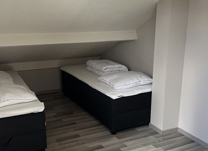 Gezellige woonkamer van TXL Huisje 299 in De Cocksdorp, Texel met comfortabele zithoek en toegang tot het terras.