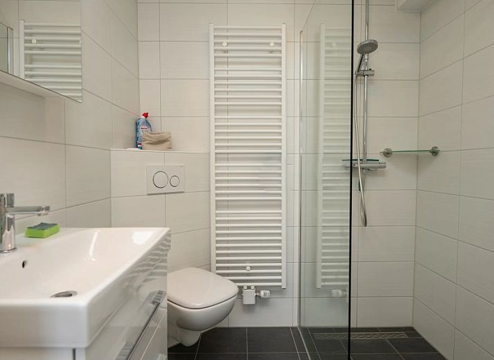 Gezellige slaapkamer in TXL Huisje 299, een vakantiehuis in De Cocksdorp op Texel, Waddeneilanden, met comfortabele bedden onder een schuin dak.