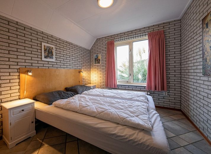 Gezellige woonkamer in Vakantiehuis Schelpenoord 129, De Cocksdorp, Texel, met comfortabele zitruimte en uitzicht op groene omgeving.