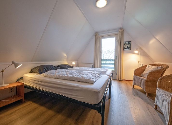 Gezellige woonkamer in Vakantiehuis Schelpenoord 129, De Cocksdorp, Texel, met comfortabele zitruimte en uitzicht op groene omgeving.