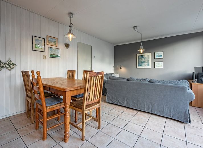 Geniet van het zonnige terras bij Vakantiehuis Slufterhoek 114 in De Cocksdorp, Texel, met comfortabele zitplaatsen en parasol.