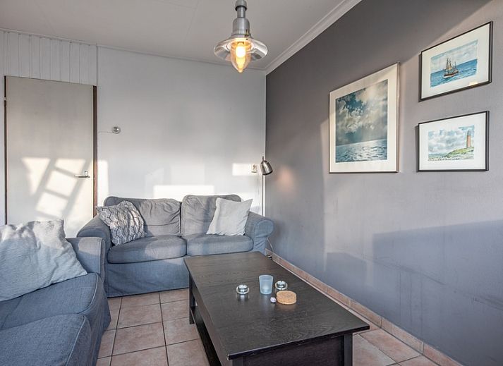 Geniet van het zonnige terras bij Vakantiehuis Slufterhoek 114 in De Cocksdorp, Texel, met comfortabele zitplaatsen en parasol.