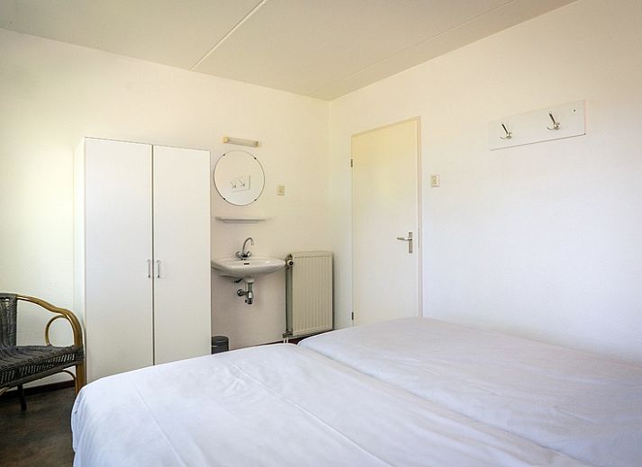 Terrasse von Bungalow De Witte Hoek 5 pers. 142 in De Cocksdorp Texel, mit Sonnenschirm und Sitzgelegenheit auf den Watteninseln.