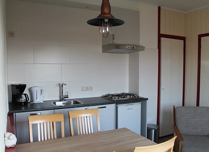 Moderne keuken in vakantiehuis Onder de vuurtoren 115, De Cocksdorp, Texel met eethoek en kookfaciliteiten.