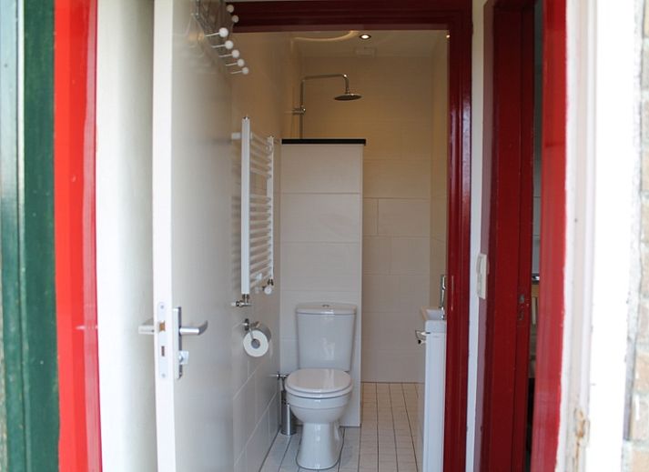 Gezellig terras bij Onder de vuurtoren 115, vakantiehuis in De Cocksdorp, Texel met houten schutting en tuinmeubilair.