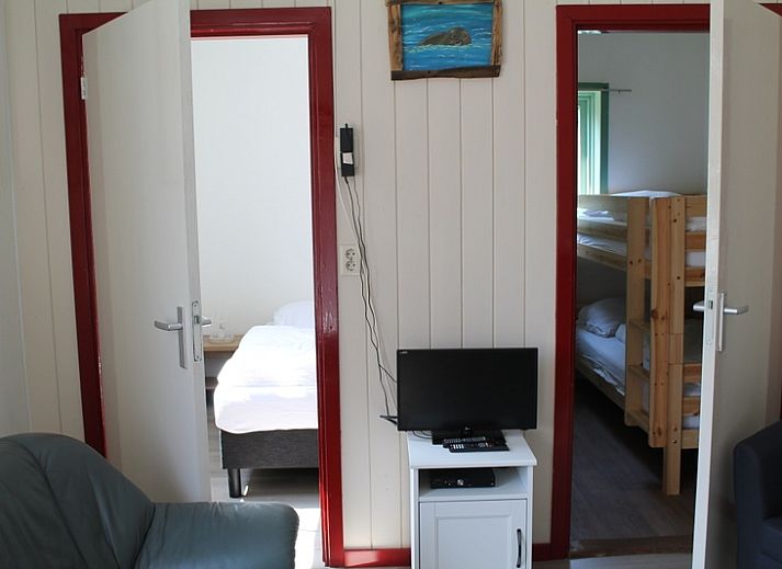 Gezellig terras bij Onder de vuurtoren 115, vakantiehuis in De Cocksdorp, Texel met houten schutting en tuinmeubilair.