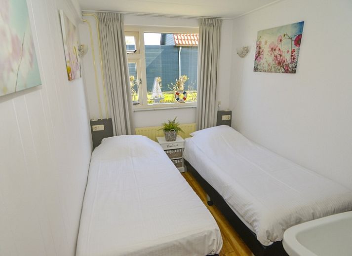 Terrace of vacation home Duinviooltje in De Cocksdorp, Texel with wooden bench and garden table.