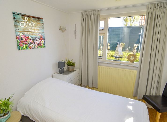 Terrace of vacation home Duinviooltje in De Cocksdorp, Texel with wooden bench and garden table.