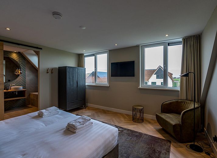 View from the living room of Princenhof 1 - 6-pers in De Cocksdorp, Texel with modern furnishings and terrace.