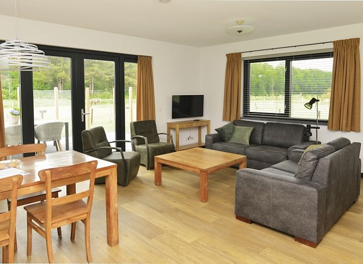 De Postschipper vakantiehuis met rieten dak in De Cocksdorp, Texel, omringd door groen.