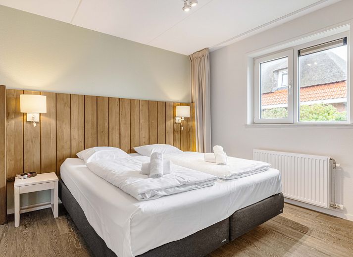 Ruime zitkamer met open haard in Sluftervallei 8-persoons bungalow, Texel.