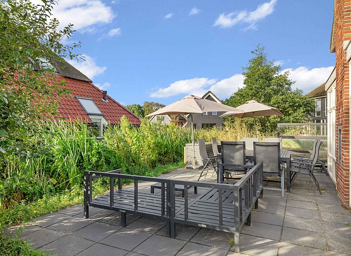 Ruime zitkamer met open haard in Sluftervallei 8-persoons bungalow, Texel.