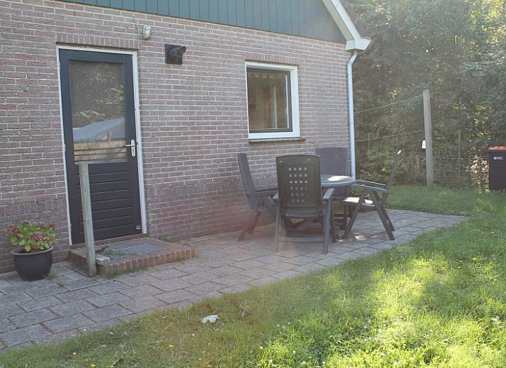 Dune/lighthouse view detached vacation home in De Cocksdorp, Texel with green garden and bench in front.