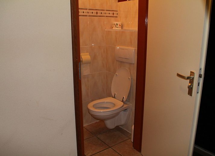 Dune/lighthouse view detached vacation home in De Cocksdorp, Texel with green garden and bench in front.