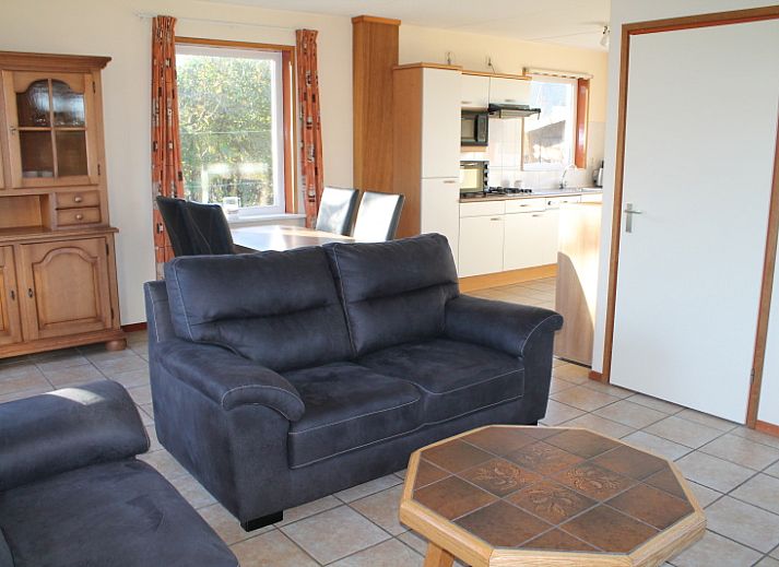 Dune/lighthouse view detached vacation home in De Cocksdorp, Texel with green garden and bench in front.