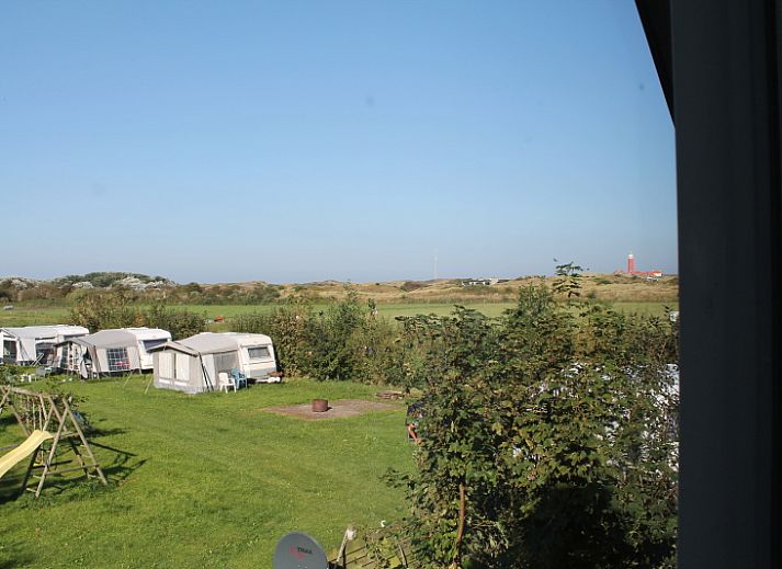 Terrace of Duin-/vuurtorenzicht detached vacation home in De Cocksdorp, Texel with garden chairs and table.