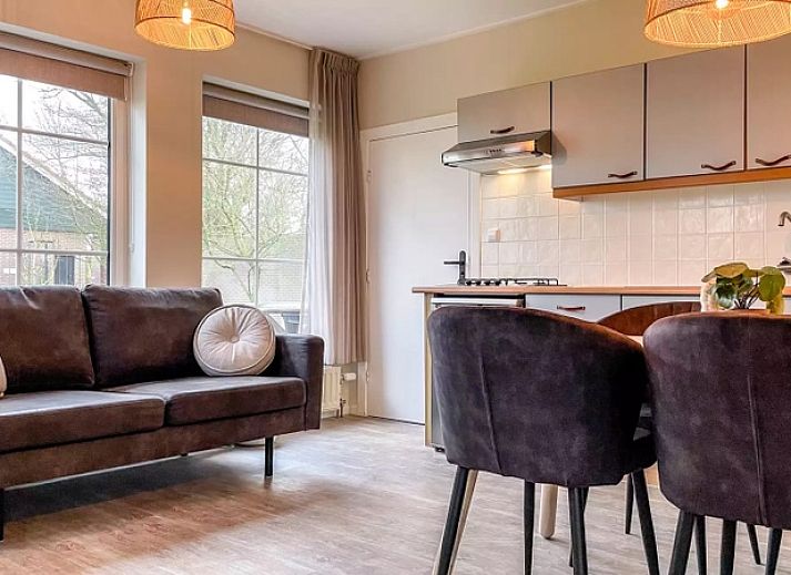 Gezellige woonkamer Vakantiehuis Hogezandskil in De Cocksdorp op Texel met comfortabele bank en grote ramen.