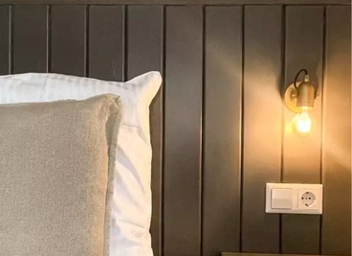 Gezellige woonkamer Vakantiehuis Hogezandskil in De Cocksdorp op Texel met comfortabele bank en grote ramen.