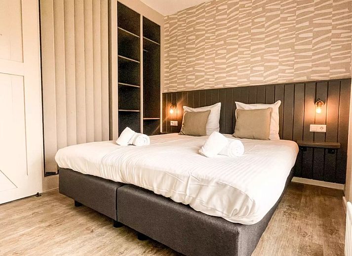 Gezellige woonkamer Vakantiehuis Hogezandskil in De Cocksdorp op Texel met comfortabele bank en grote ramen.