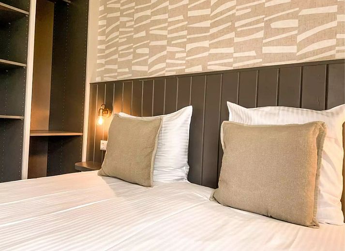 Gezellige woonkamer Vakantiehuis Hogezandskil in De Cocksdorp op Texel met comfortabele bank en grote ramen.