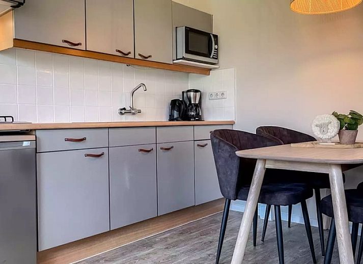Moderne keuken Vakantiehuis Hogezandskil, De Cocksdorp, Texel met eethoek en stijlvolle inrichting.