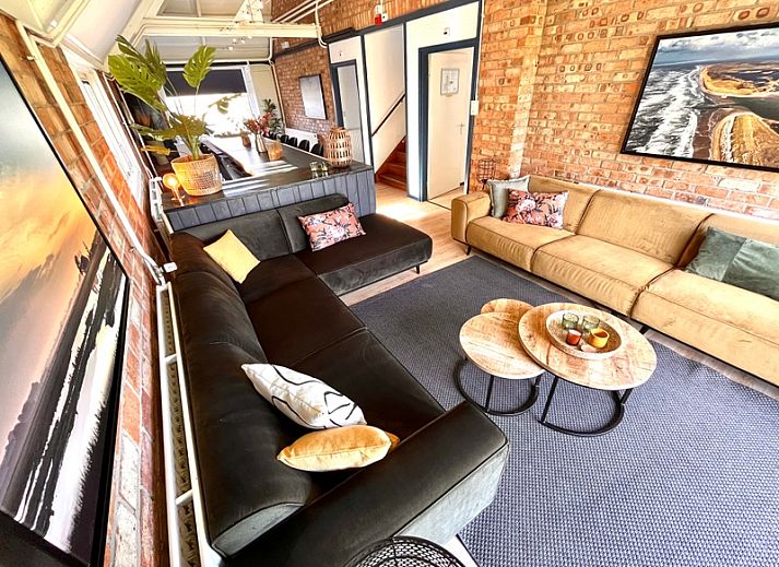 Gezellige zithoek in Noorderwind vakantiehuis, De Cocksdorp, Texel met comfortabele banken en warme inrichting.