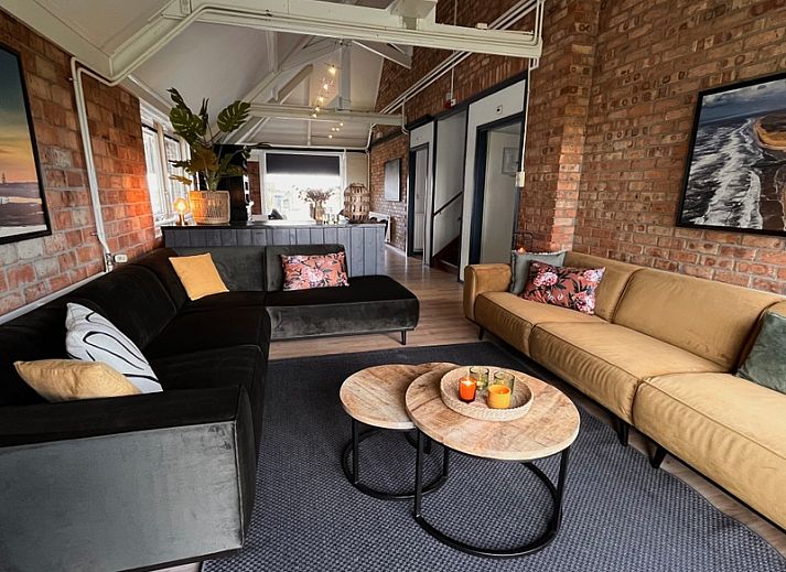 Gezellige zithoek in Noorderwind vakantiehuis, De Cocksdorp, Texel met comfortabele banken en warme inrichting.