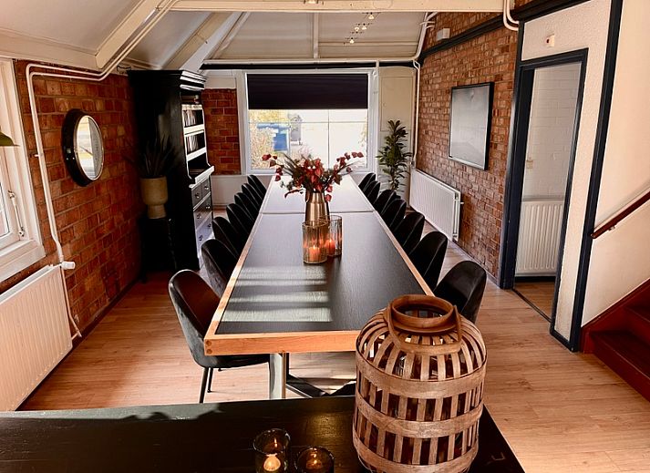 Stijlvolle woonkamer in Noorderwind accommodatie, De Cocksdorp, Texel met moderne meubels en kunst aan de muur.