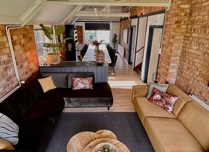 Stijlvolle woonkamer in Noorderwind accommodatie, De Cocksdorp, Texel met moderne meubels en kunst aan de muur.