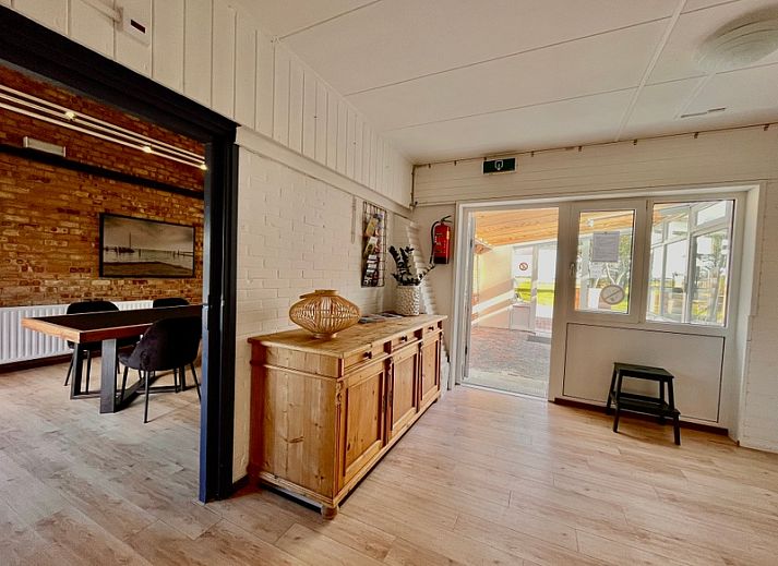 Stijlvolle woonkamer in Noorderwind accommodatie, De Cocksdorp, Texel met moderne meubels en kunst aan de muur.